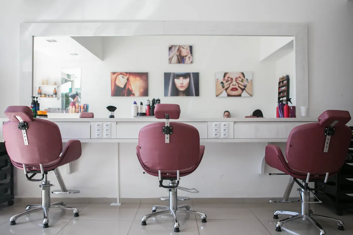 Interior da Alta Barbearia com cadeiras de couro e iluminação âmbar